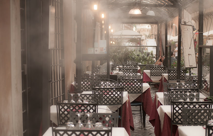 Empty restaurant terrace with set tables and red tablecloths