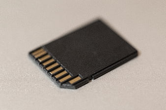 Close-up of black SD memory card on white surface