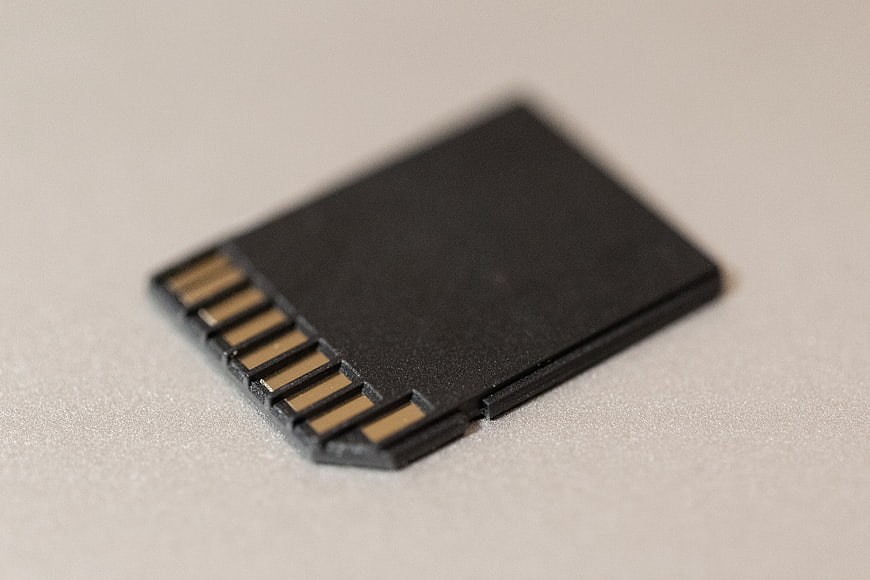 Close-up of black SD memory card on white surface