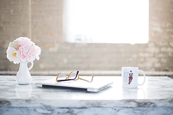 Minimalist Workspace with Laptop, Glasses, and Pink Flowers