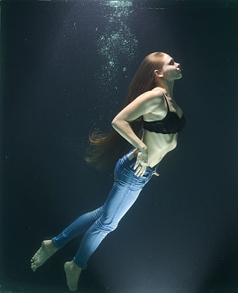Underwater portrait of woman in jeans and black bra