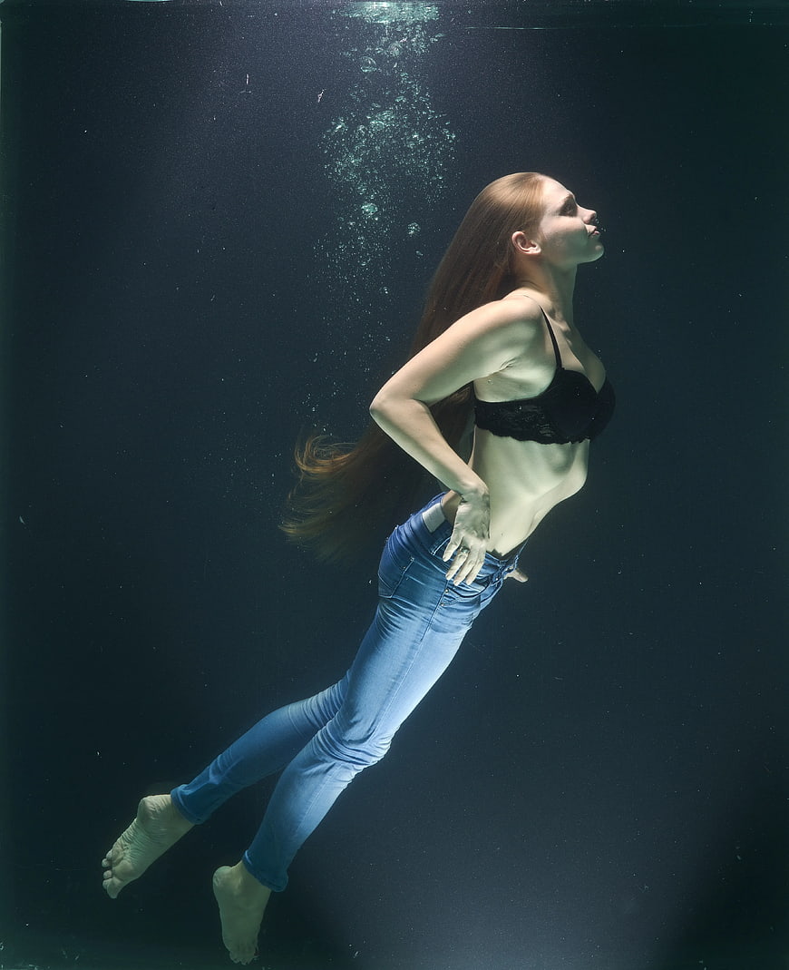 Underwater portrait of woman in jeans and black bra