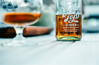 Gold Top Cider Bottle and Glass on Wooden Table