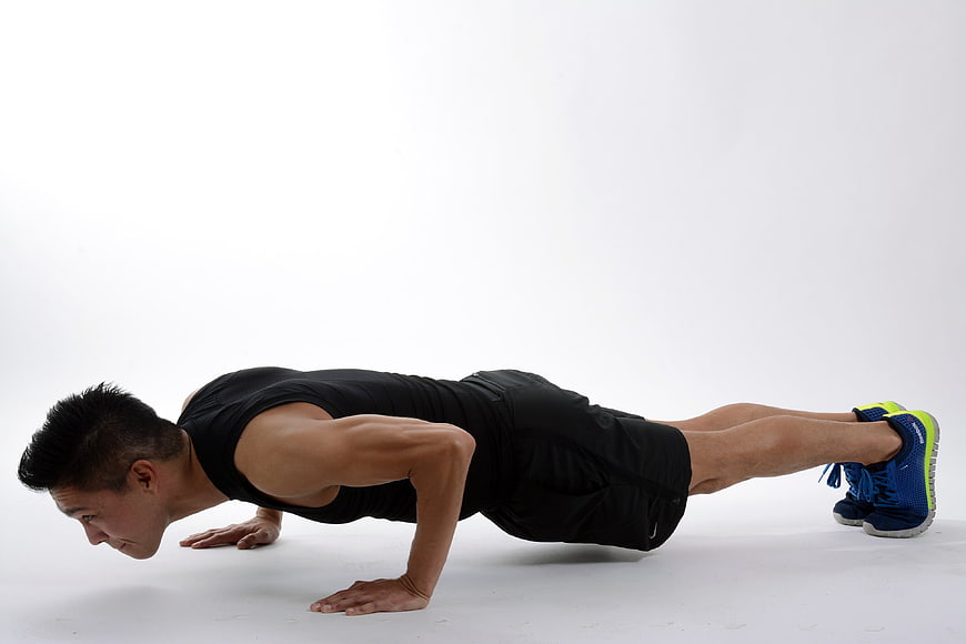 Athletic Man Performing Push-Up Exercise in Studio