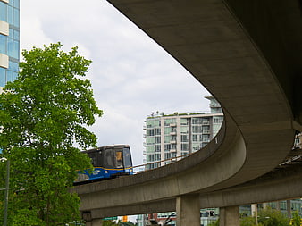 Blue SkyTrain on Elevated Track in Vancouver Urban Landscape