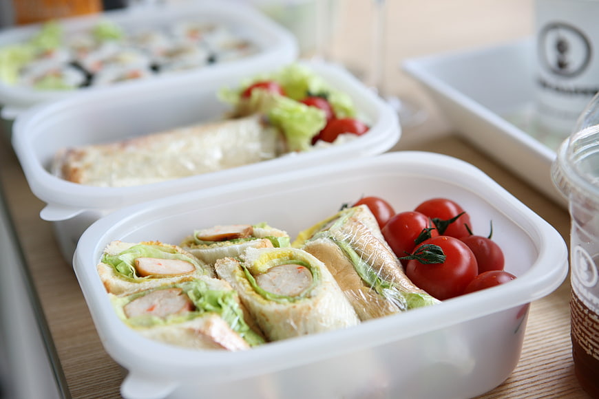 Fresh Sandwiches And Cherry Tomatoes In White Takeaway Containers