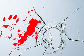 Shattered glass with red paint splatter and handprint on white background