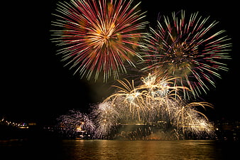 Colorful Fireworks Display Over Water at Night