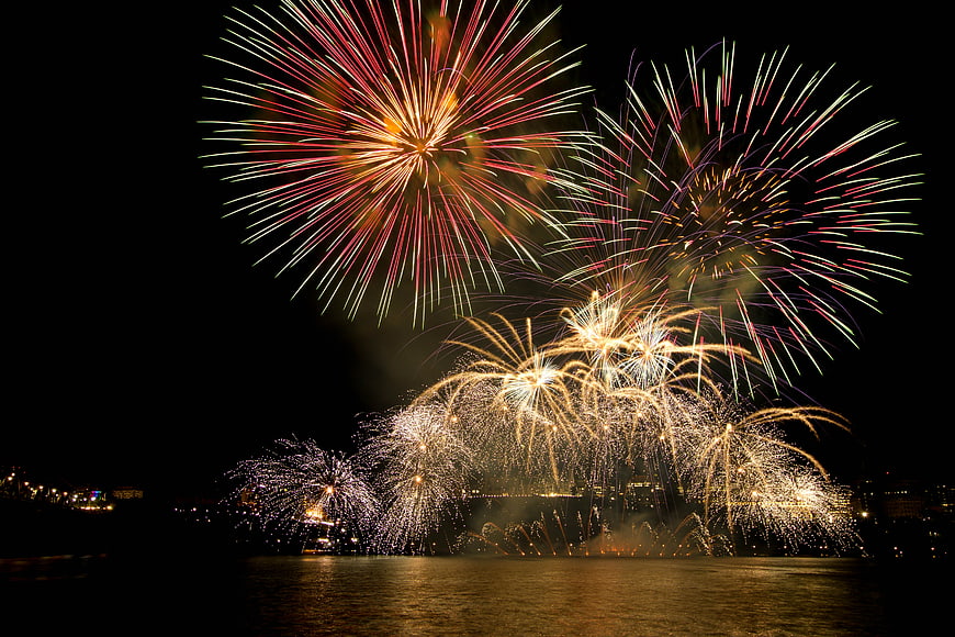 Colorful Fireworks Display Over Water at Night