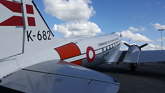 Vintage propeller airplane tail with red markings on airfield