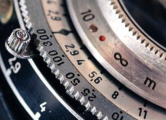 Close-up of vintage camera lens focus ring and aperture settings