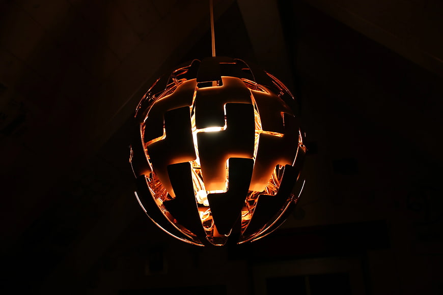 Modern spherical pendant lamp glowing in dark interior