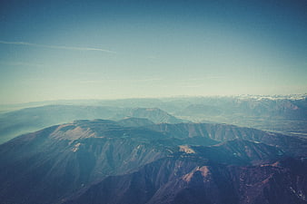 Aerial View of Layered Mountain Ranges with Snow-Capped Peaks