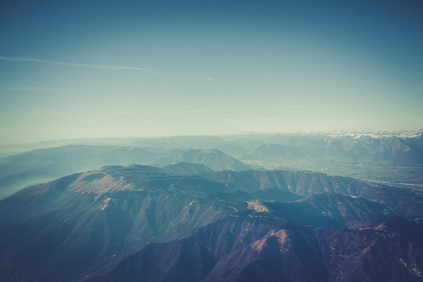 Aerial View of Layered Mountain Ranges with Snow-Capped Peaks