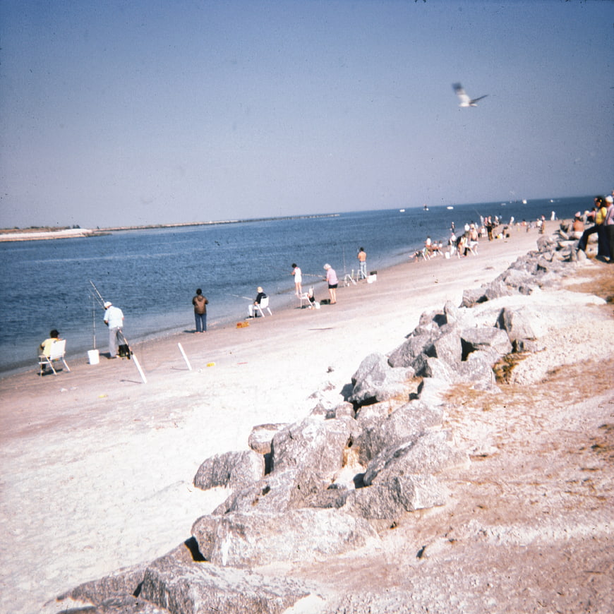 Vintage Film Photo of People Fishing on Sandy Beach