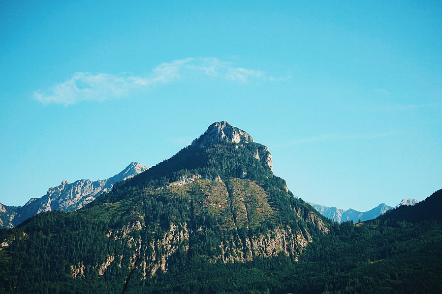 Majestic Mountain Peak with Forest Slopes and Blue Sky