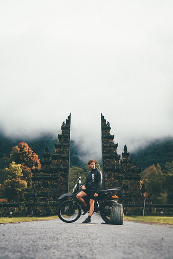 Man on Adventure Motorcycle in Front of Misty Temple Ruins