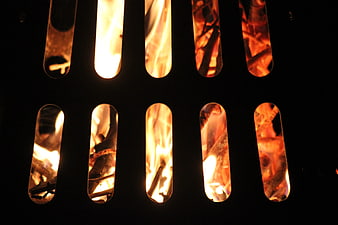 Close-up of burning wood fire through metal grate