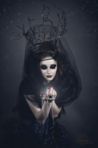Gothic witch with glowing hands and antler crown