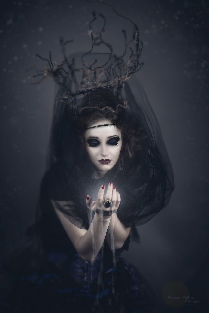 Gothic witch with glowing hands and antler crown