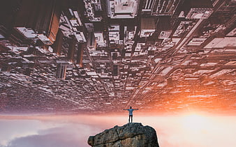 Surreal man standing on cliff overlooking inverted snowy city