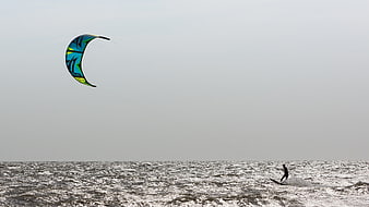 Kite Surfer Riding Choppy Gray Sea Under Overcast Sky