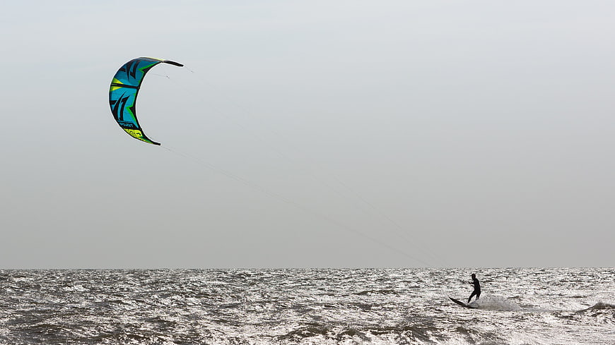 Kite Surfer Riding Choppy Gray Sea Under Overcast Sky
