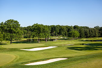 Wide View of Lush Green Golf Course with Sand Traps and Trees