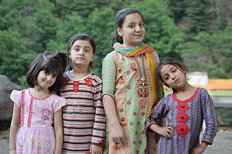 Four young girls posing outdoors in colorful traditional clothing