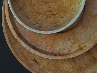 Stacked wooden bowls on dark background top view