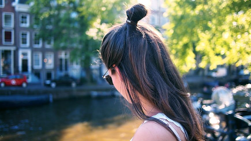 Woman with Top Knot Bun Looking at Canal in Amsterdam
