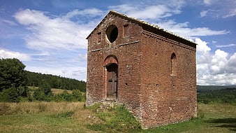 Ancient red brick church in Tuscan landscape