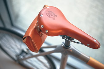 Close-up of brown leather bicycle saddle with matching bag