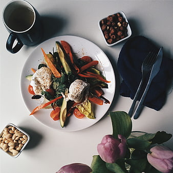 Healthy poached egg breakfast salad with avocado and nuts