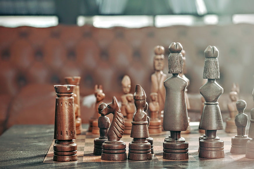Close-up of wooden chess pieces on a board with leather background
