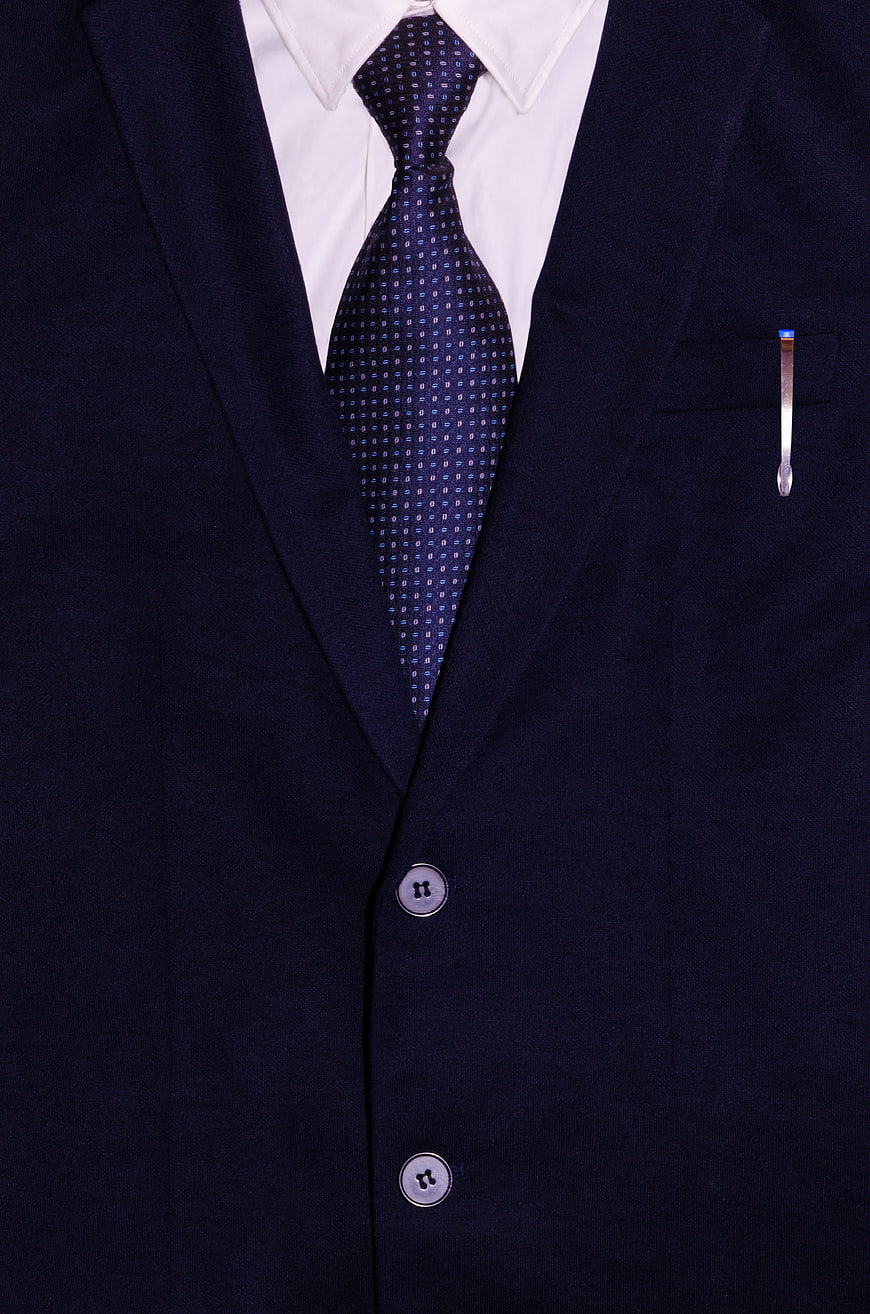 Close-up of navy blue business suit with patterned tie