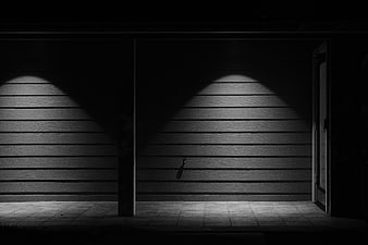 Dramatic black and white night scene with spotlights on siding
