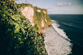 Lush Green Cliff Overlooking Ocean Waves