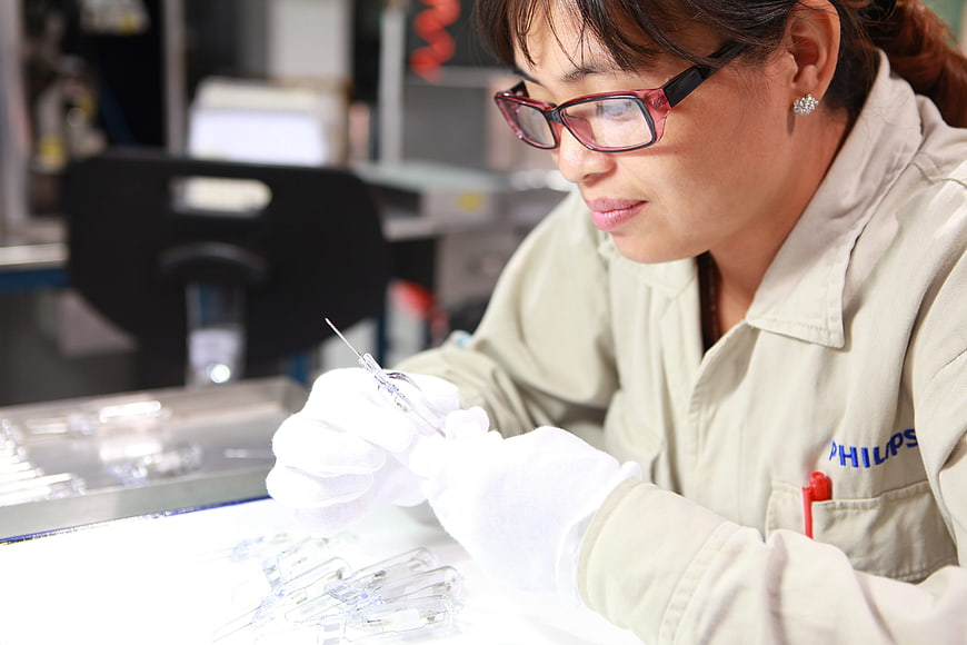 Female Technician Inspecting Components In Industrial Laboratory