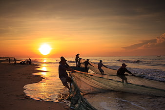 Vietnamese Fishermen Pulling Nets on Beach at Sunrise