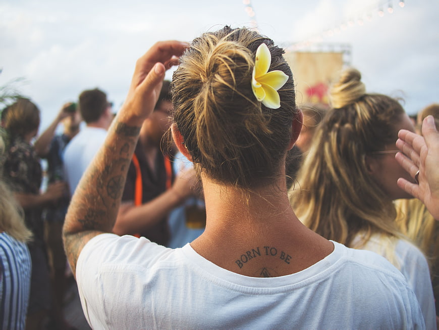 Back view of man with flower in hair at outdoor festival