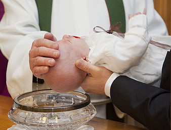 Close-up of baby baptism with water pouring on head
