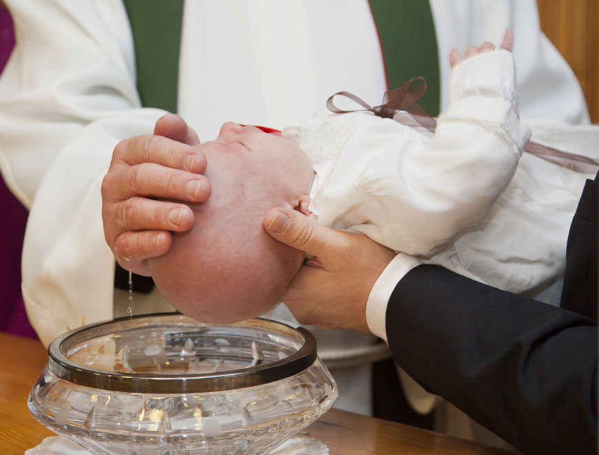 Close-up of baby baptism with water pouring on head