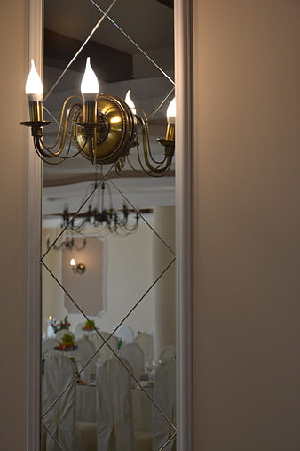 Vintage brass wall sconce reflected in diamond mirror