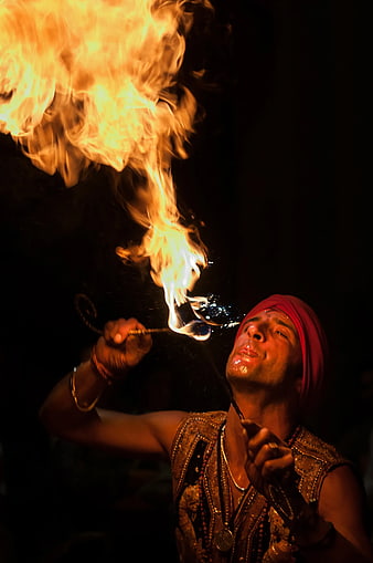 Man Performing Fire Breathing Act at Night