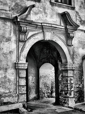 Black and white photo of weathered stone archway