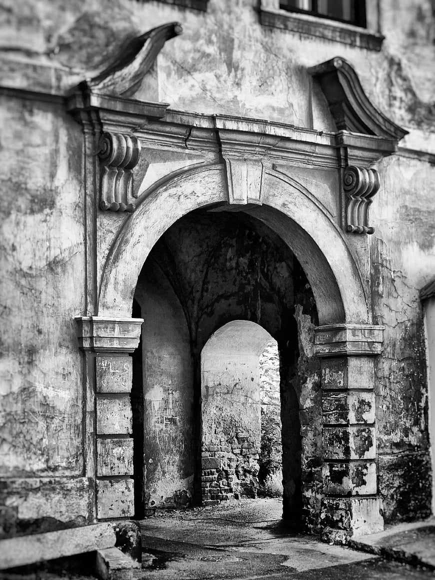Black and white photo of weathered stone archway