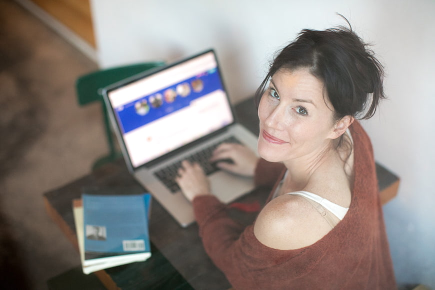 High angle view of smiling woman working on laptop