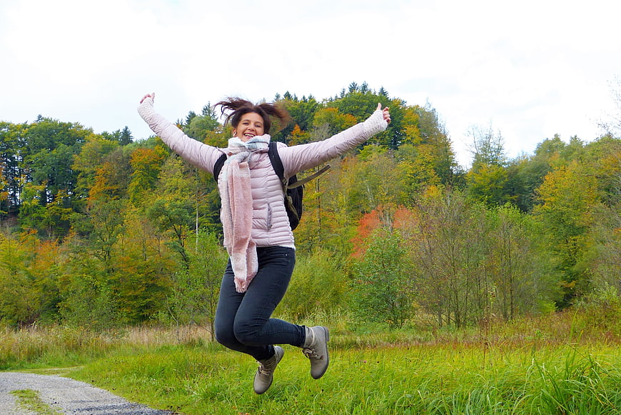 Happy Woman Jumping in Autumn Forest Meadow