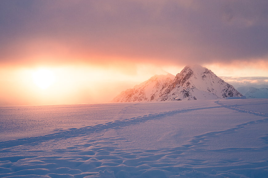 Snowy Mountain Landscape at Sunset with Tracks in Snow
